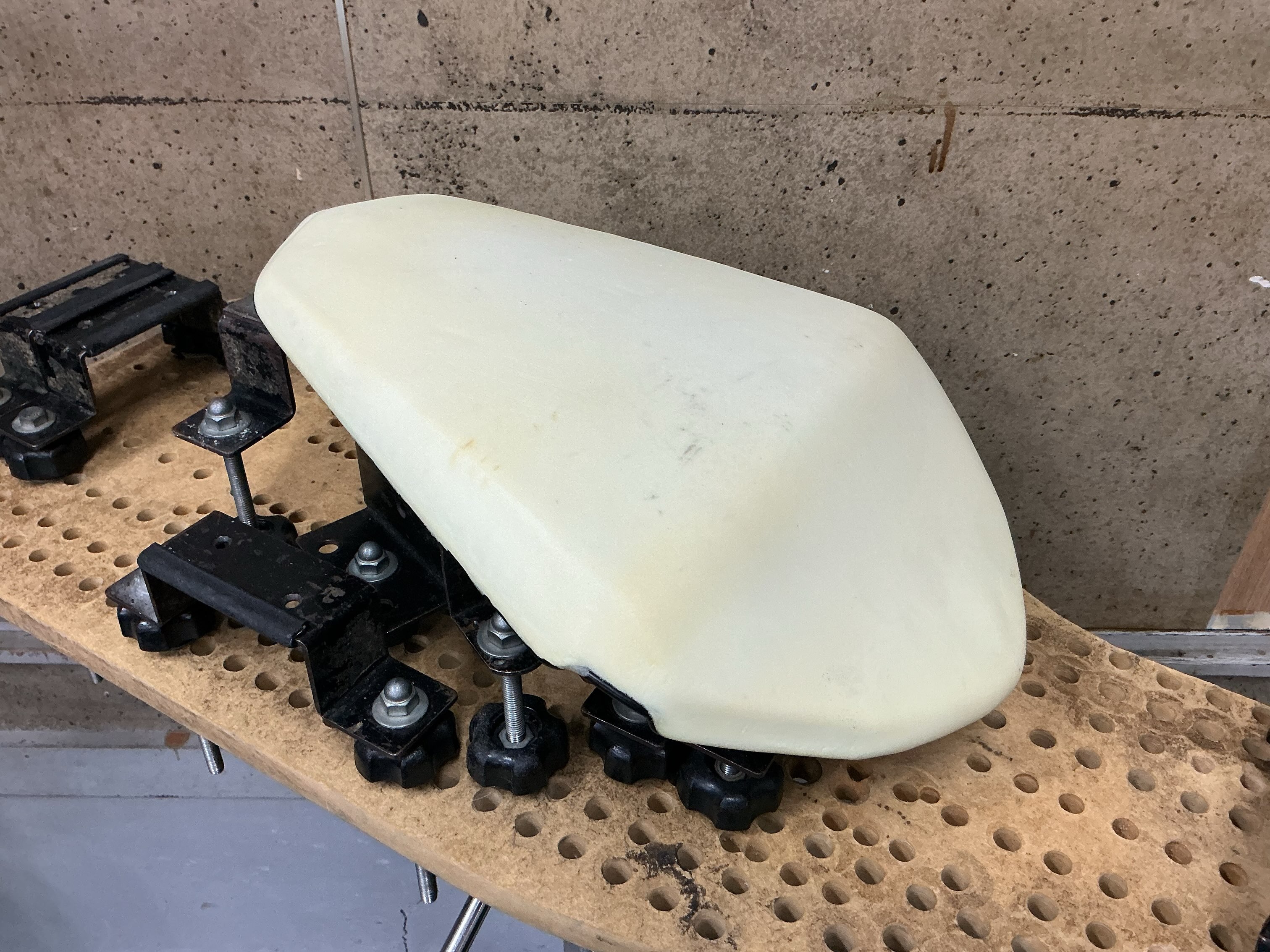 GSX8Sの表皮を外した加工前のウレタン座面。作業台の治具で支えている状態